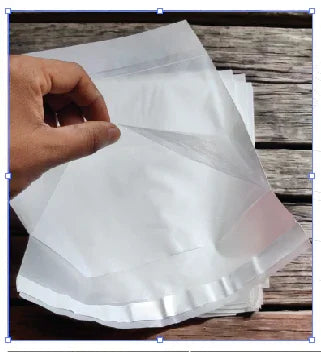 Clear stand-up zipper pouches for food packaging, held over rustic wood surface